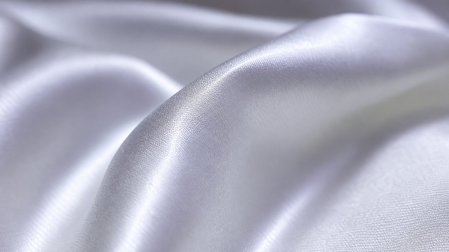 Extreme close-up of smooth white silk fabric with a liquid sheen in raking light.