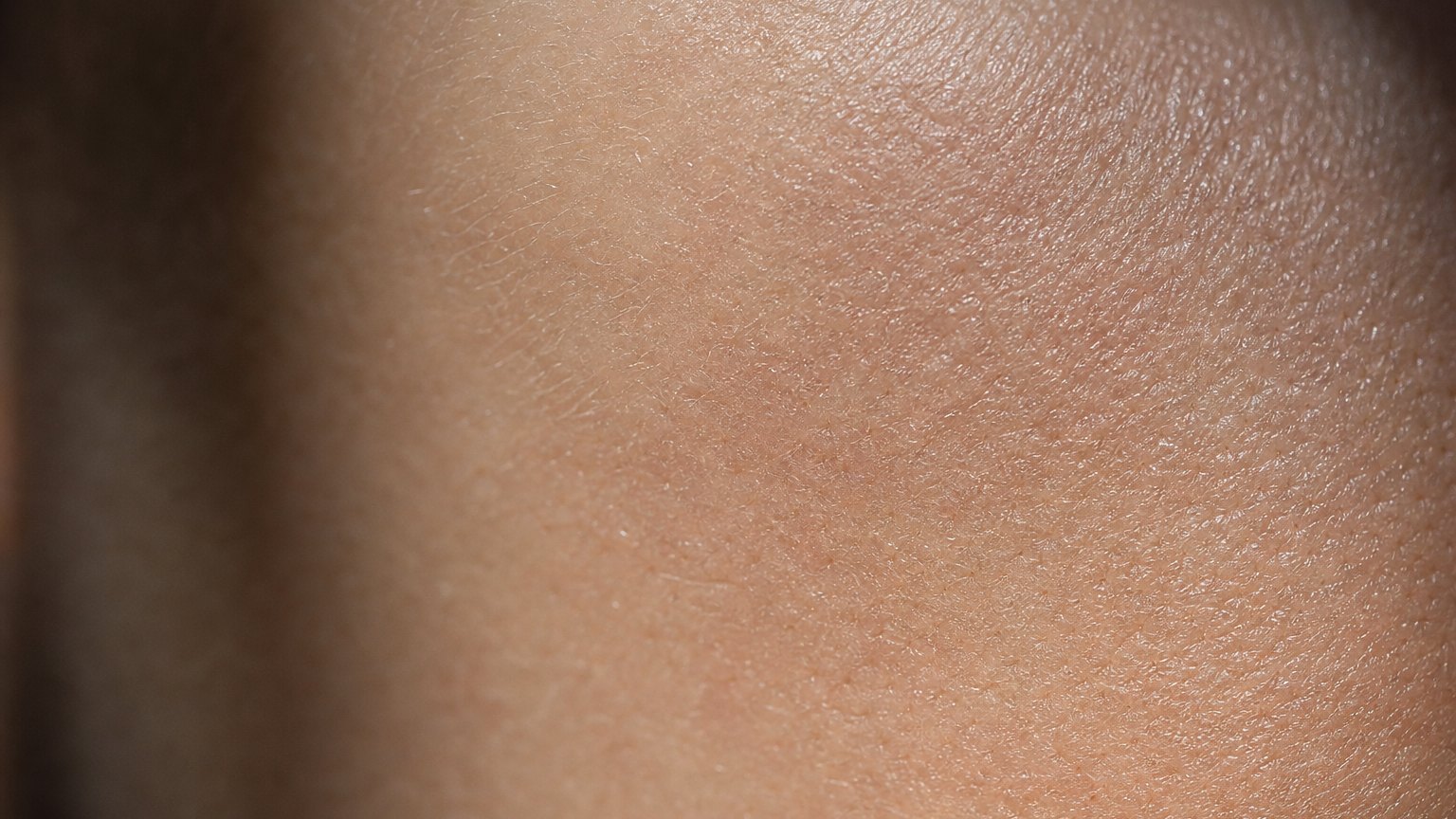Macro close-up of healthy human skin texture in soft light.